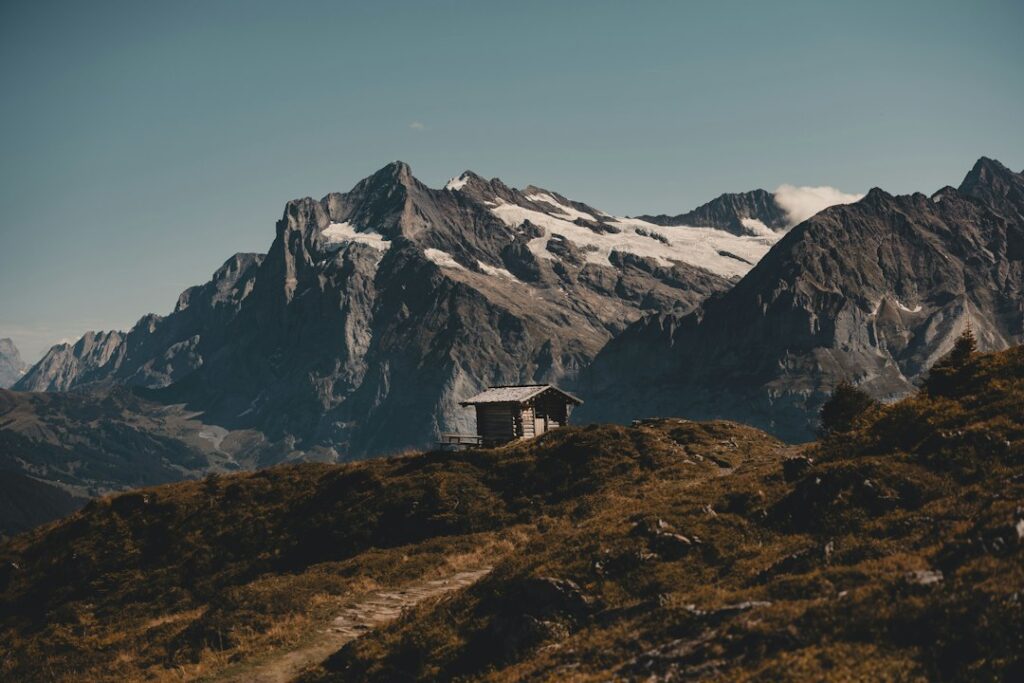 Small house on a grassy hill with mountains behind it representing Colorado homeowners facing foreclosure in 2026