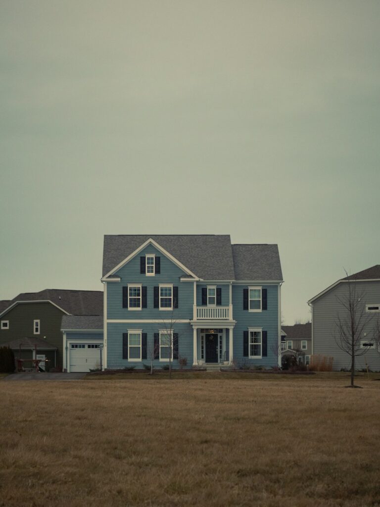 Blue two-story house with black shutters representing a home that is not selling in a 2026 buyer's market