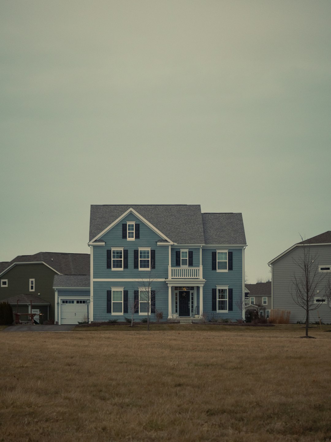 Blue two-story house with black shutters representing a home that is not selling in a 2026 buyer's market