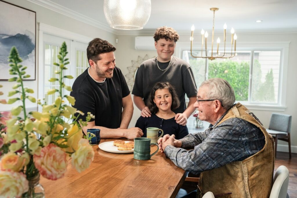 Family gathered around a wooden table talking through an inherited house with siblings