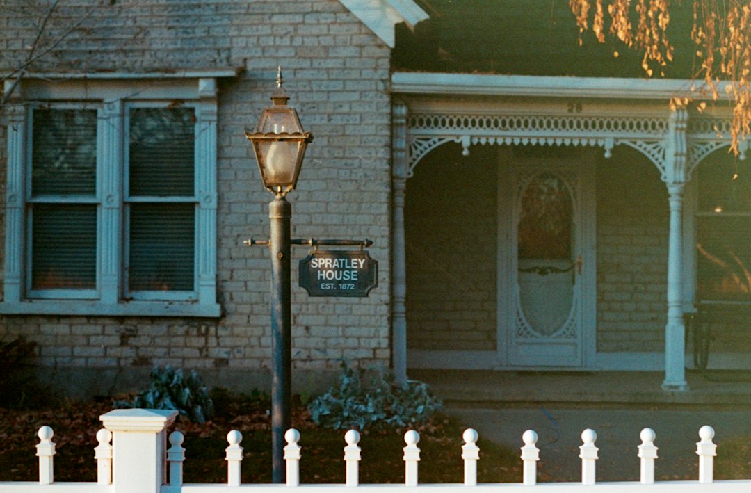 Older home with a white fence representing a seller weighing a sale as mortgage rates climb to 7.40%